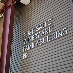 Exterior view of the E. & J. Gallo Winery and Family Building with signage mounted on a metal facade.