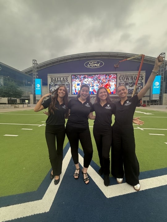 Group of students posing on the field outside a football stadium during a business, technology, or innovation competition event.