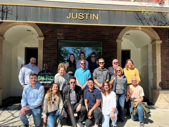 Group of students and industry professionals posing outside Justin Vineyards during an educational winery tour experience.