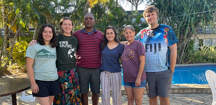 Group portrait of students and community members standing together outdoors during an international engineering or sustainability outreach project in Fiji.