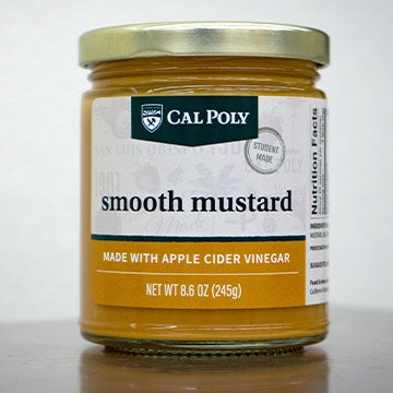 Glass jar of Cal Poly smooth mustard with a white label and gold lid displayed against a plain background.