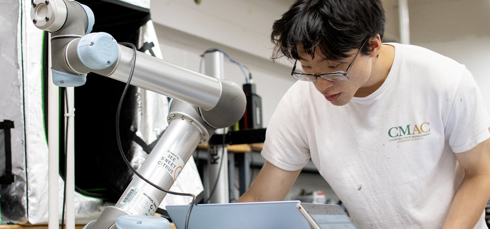 A student works on a automated arm that will be used to harvest grapes.  