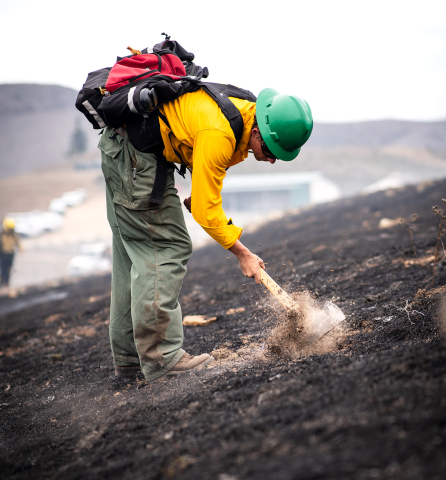 A student checks for hot spots following a controlled burn on Cal Poly land. 