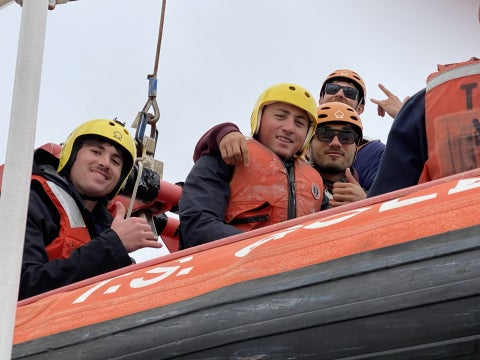 Cal Poly Maritime Academy students smile at the camera. 
