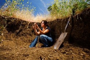 Environmental earth and soil sciences student Nabila Wildman collecting soil samples on campus.