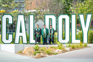 The Godoy graduates stand in front of the Cal Poly sign. 