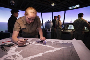 A Marine Transportation student studies a map on the bridge of the Training Ship Golden Bear. 