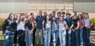 A group of students stand with honored alumni Tim Doelman.