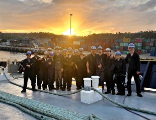 Cal Poly Maritime Academy cadets stand together for a group photo on the deck of the Training Ship Golden Bear. 