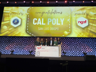 Students stand on stage with a large check representing their winnings from the National Grocers Association Foundation. 