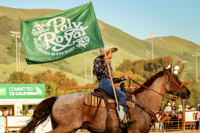 A student rides out with the Poly Royal flag to start the Cal Poly Rodeo