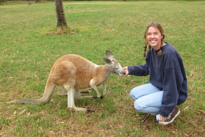 A Cal Poly student with a kangaroo while studying abroad in Australia. 