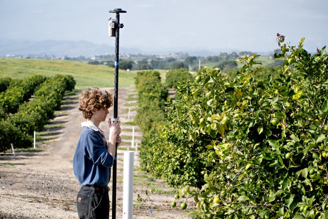 A geographic information systems student takes a reading at Cal Poly's Bartleson Ranch.