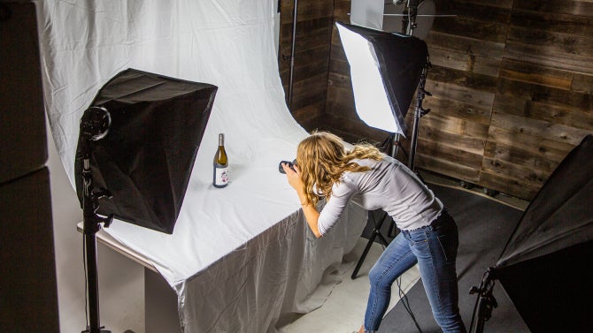 An agricultural communications student in a photography studio in the Brock Center at Cal Poly