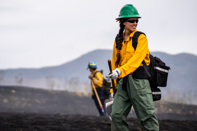 A student participates in a prescribed burn on Cal Poly's campus. 