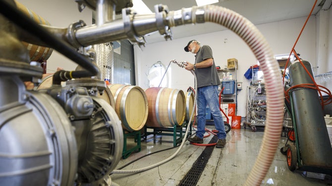 A Cal Poly Winery Supervisor and enology lecturer, combines three different red wine varietals into wine blending tanks before being filtered and bottled in about 2 or 3 weeks time.