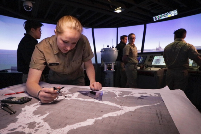 A Marine Transportation student studies a map on the bridge of the Training Ship Golden Bear. 