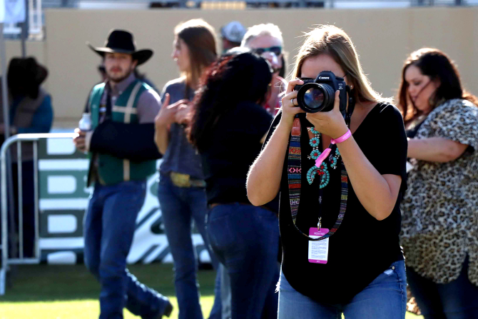 A student photographs the Poly Royal Rodeo. 