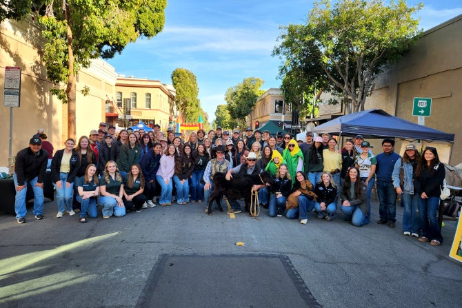 A large group of students pose for a photo during the Downtown Farmers' Market Club Showcase. 