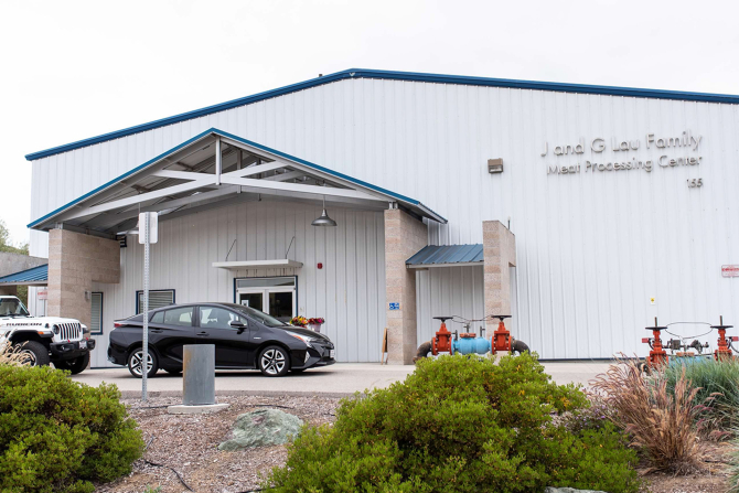 Cars line up in front of the J and G Lau Family Meat Processing Center.