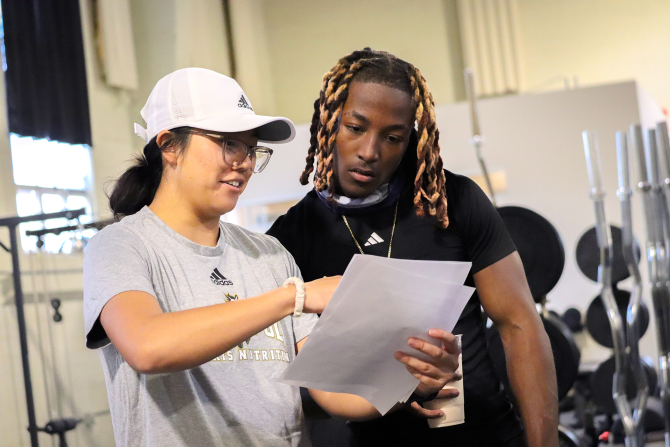 A nutrition student works with a student athlete on a individually designed meal plan.