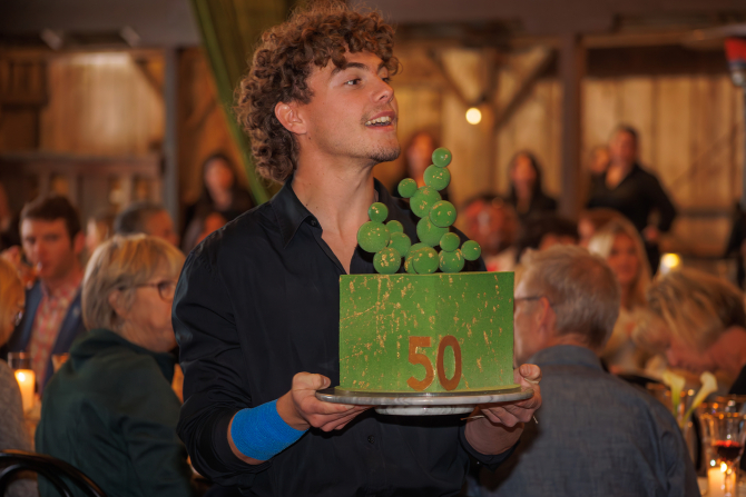 An Experience Industry Management student delivers a gift during the auction. 