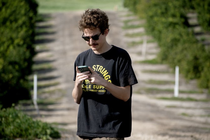 A student works to GIS map lemon groves at Bartleson Ranch. 
