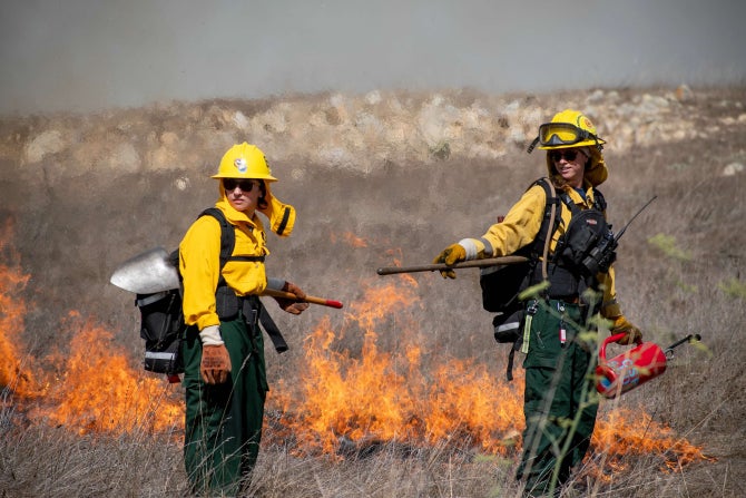 Students participate in a prescribed burn on campus. 