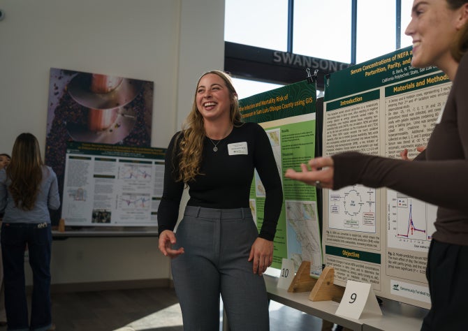 A student talks with an industry professional during a research symposium. 