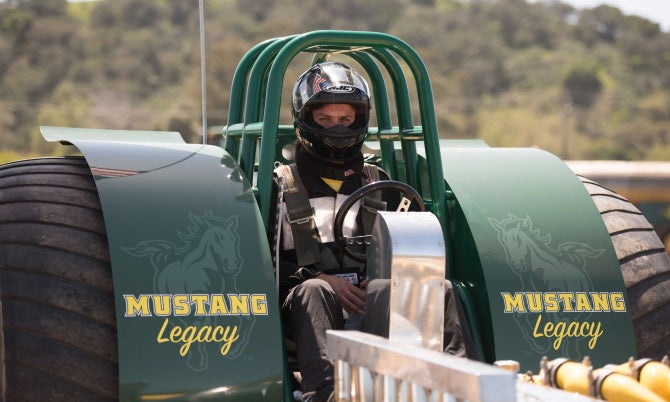 A member of the Tractor Pull Team sits in the cockpit of Mustang Legacy waiting for his run. 