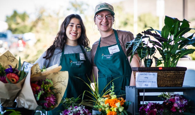 Two students from the Poly Plant shop smile at the camera. 